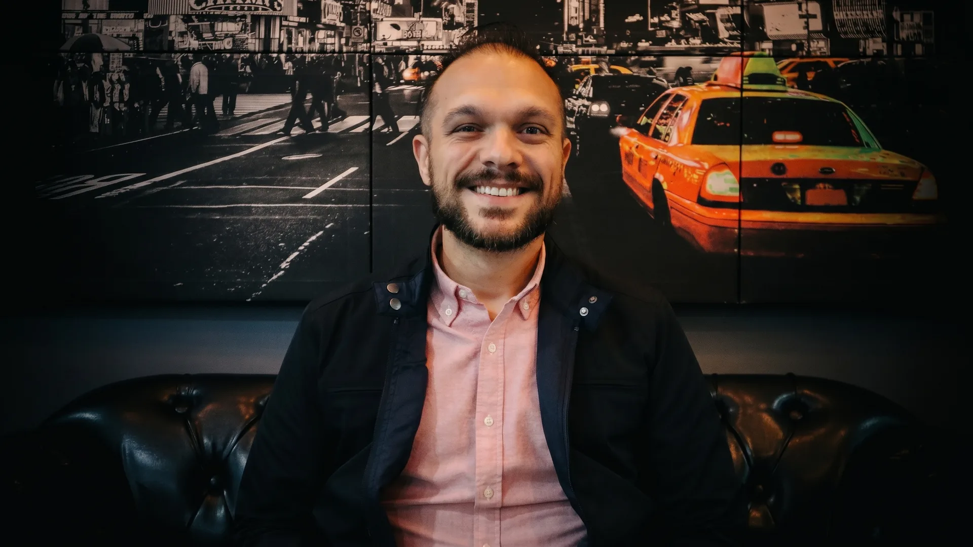 Joao Roverci em sofa com painel automotivo ao fundo